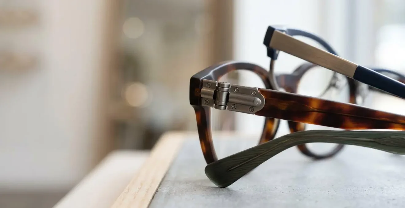 Détails de montures de lunettes élégantes présentées sur un présentoir d'opticien avec lumière naturelle